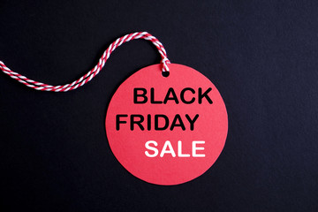 Wall Mural - Black friday sale concept. Fourth Friday of November, beginning of Christmas shopping season since 1952. Red tag with black text on bright red background. Copy space, close up, top view, flat lay.