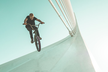 Wall Mural - Young man doing street tricks with a bmx