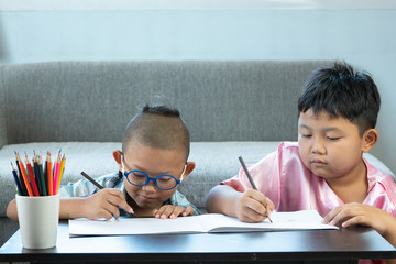 Boy and friends intend drawing a picture fun, enjoy drawing or write in book at home.