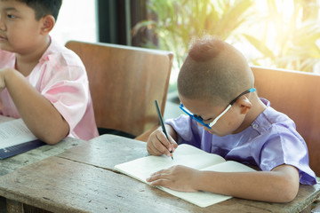 Cute asian boy write homework at home. education concept