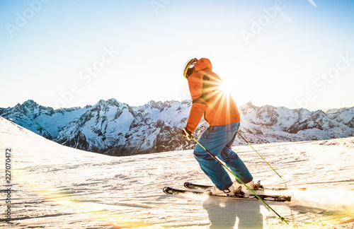 Fotografie, Obraz Professional skier athlete skiing at sunset on top of french alps ski resort - W