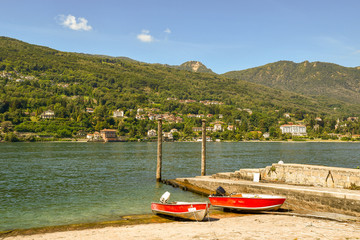 Sticker - Barche di pescatori al molo del lago con veduta su costa e montagne, Isola dei Pescatori, Lago Maggiore, Italia