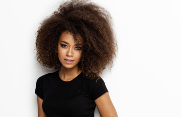 Wall Mural - Portrait of young african american woman with afro looking at camera