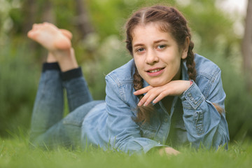 portrait of  teenager while lying in summer green park