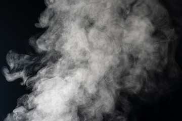 White smoke on a black background. Texture of smoke. Clubs of white smoke on a dark background for overlay