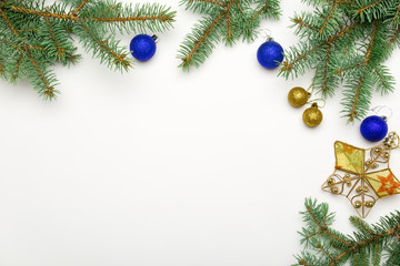 Holiday frame of Christmas decorations on white background with fir branch, gold and red balls, stars. Elegant New Year`s snowy card. Top view. Flat lay.