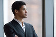 © fizkes - Thoughtful African American millennial employee looking in distance thinking of future career opportunities, serious black businessman dreaming of achievements or success. Concept of business vision