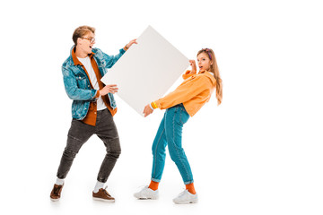 cheerful hipster couple holding empty banner isolated on white