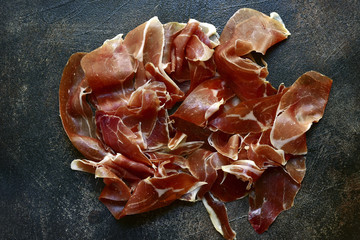 Prosciutto di parma or jamon serrano (iberico). Top view with copy space.