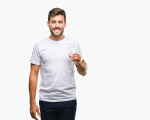 Young handsome man drinking glass of water over isolated background with a happy face standing and smiling with a confident smile showing teeth