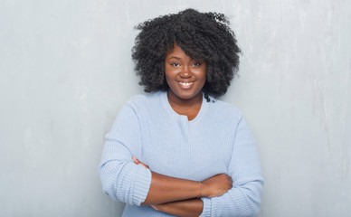 Poster - Young african american woman over grey grunge wall wearing winter sweater happy face smiling with crossed arms looking at the camera. Positive person.