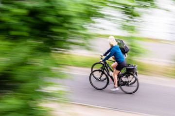 Wall Mural - two bicycle riders on a cycle path in motion blur