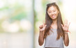 © Krakenimages.com - Young asian woman wearing sunglasses over isolated background showing and pointing up with fingers number seven while smiling confident and happy.