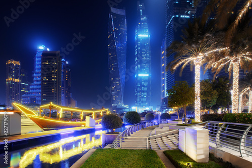 Obraz Dibond Beautiful view to Dubai Marina, UAE. Illuminated boat and palms. Long exposure time lapse effect at night