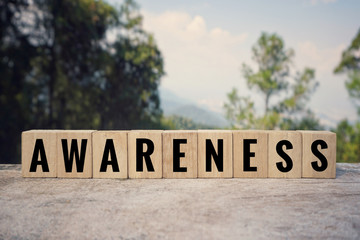 Motivational and inspirational word - ‘AWARENESS’ written on wooden blocks. Blurred styled background.	
