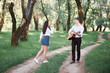 © soleg - young couple walking in the forest and playing guitar, summer nature, bright sunlight, shadows and green leaves, romantic feelings