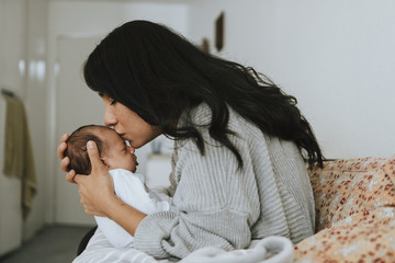 Wall Mural - loving mother kissing her infant baby