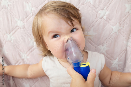 Fotografija baby girl sick and don't want to use nebulizer mask making inhalation, respiratory procedure by pneumonia or cough for child, inhaler, compressor nebulizer, health care