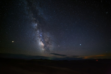 Bright stars of the Milky Way in the night sky. Foggy mist over the highlands. North Caucasus in Russia.