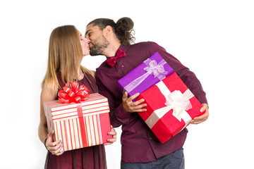 Wall Mural - Kissing couple, man and woman with a gift in their hands on light background.