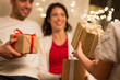 holidays, family and celebration concept - close up of happy mother, father and little daughter exchanging christmas gifts at home