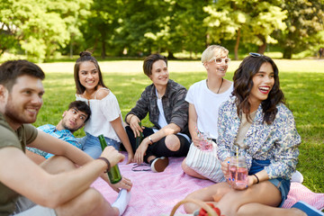 Canvas Print - friendship and leisure concept - group of happy friends with non alcoholic drinks at picnic in summer park