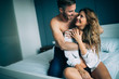 © NDABCREATIVITY - Attractive couple sharing intimate moments in bedroom