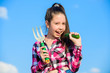 © be free - Girl gardener with hand rake. Gardening and harvesting concept. Gardening activity. Little girl gardener work at family farm. Kid cheerful gardener holds rake and cucumber blue sky background