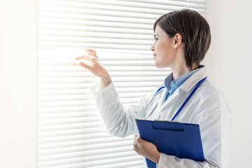 Young doctor or nurse looking through a window