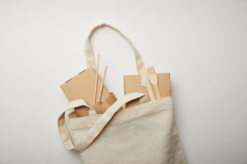 Canvas Print - top view of cotton bag with food boxes, chopsticks and disposable forks with knives on white surface