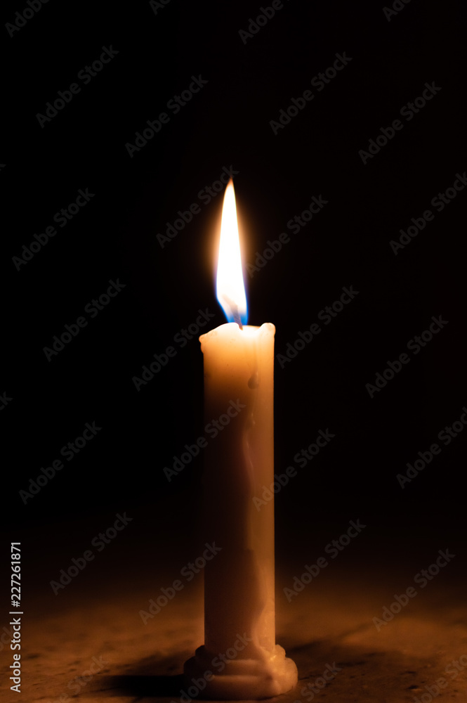 A table lit by a candle in a dark room - obrazy, fototapety, plakaty 