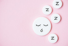 Top View Of Sleeping Pills With Drawn Face And Z Signs On Pink