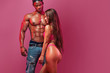 © Mike Orlov - Young fitenss athletic woman in a beautiful pink sportswear, against black athlet bodybuilder man on white background. Copyspace for sport nutrition ads.
