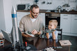 father and son repairing circuit board and looking at each other at home