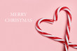 Cartel fondo Merry Christmas con bastones de caramelo sobre fondo rosa aislado. Vista superior. Copy space