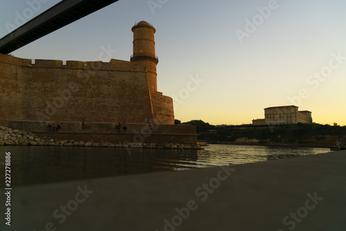 Plakat Forteca przy wejściem stary port Marseille przy półmrokiem