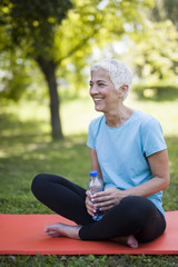 Wall Mural - Portrait of smiling senior woman relaxing after exercising