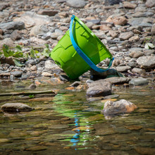 Green Bucket Pail With Reflection In Brown Water