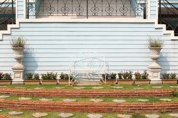 White hand made chair wrought iron with blue wall background.