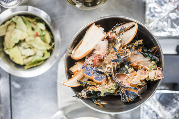 Wall Mural - Colorful lobsters in a silver bowl next to bay leaves