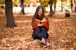© Svetlana - Beautiful girl in autumn park reading book. Girl reading