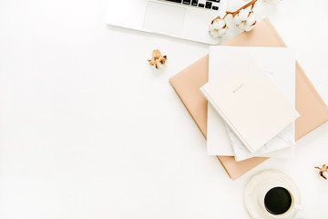 Wall Mural - Modern home office desk with laptop, notebook, coffee cup, cotton branch on white background. Flat lay, top view minimal workspace.