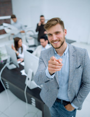 Wall Mural - young businessman standing in the office and pointing at you