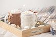 Hot chocolate with marshmallows on soft plaid background with Christmas lights. Perfect winter time treat.