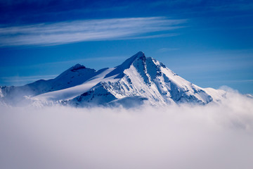 A beautiful mountain peak reaching out of the clouds on a winter day in February. Picture taken in Tignes in the Savoie department in the Rhône-Alpes region in south-eastern France