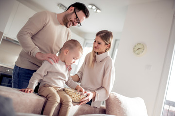 Poster - Smiling family eating popcorn at home