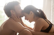 © fizkes - Close up naked loving couple in bed having fun together. Young man embrace touch kiss forehead of a happy cheerful attractive girl. Romantic sex passionate relationships and seduction foreplay concept