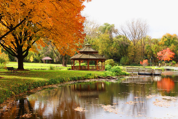 Midwest nature background with park view. Beautiful autumn landscape with colorful trees around the pond and wooden gazebo in a city park. Lakeview park, Middleton, Madison area, WI, USA.