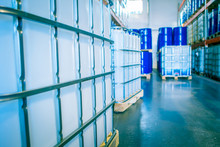 Chemical Production. Plastic Containers In Stock. Warehouse Chemicals. Blue Barrels And White Plastic Containers. Pharmaceuticals.