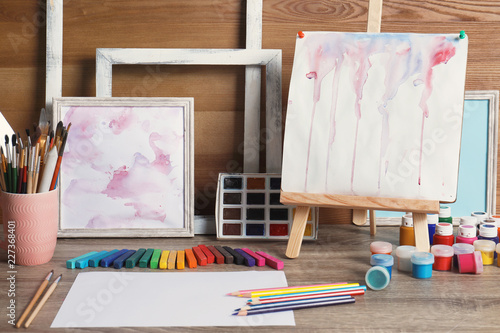 Abstract Paintings And Set Of Professional Art Supplies On Table